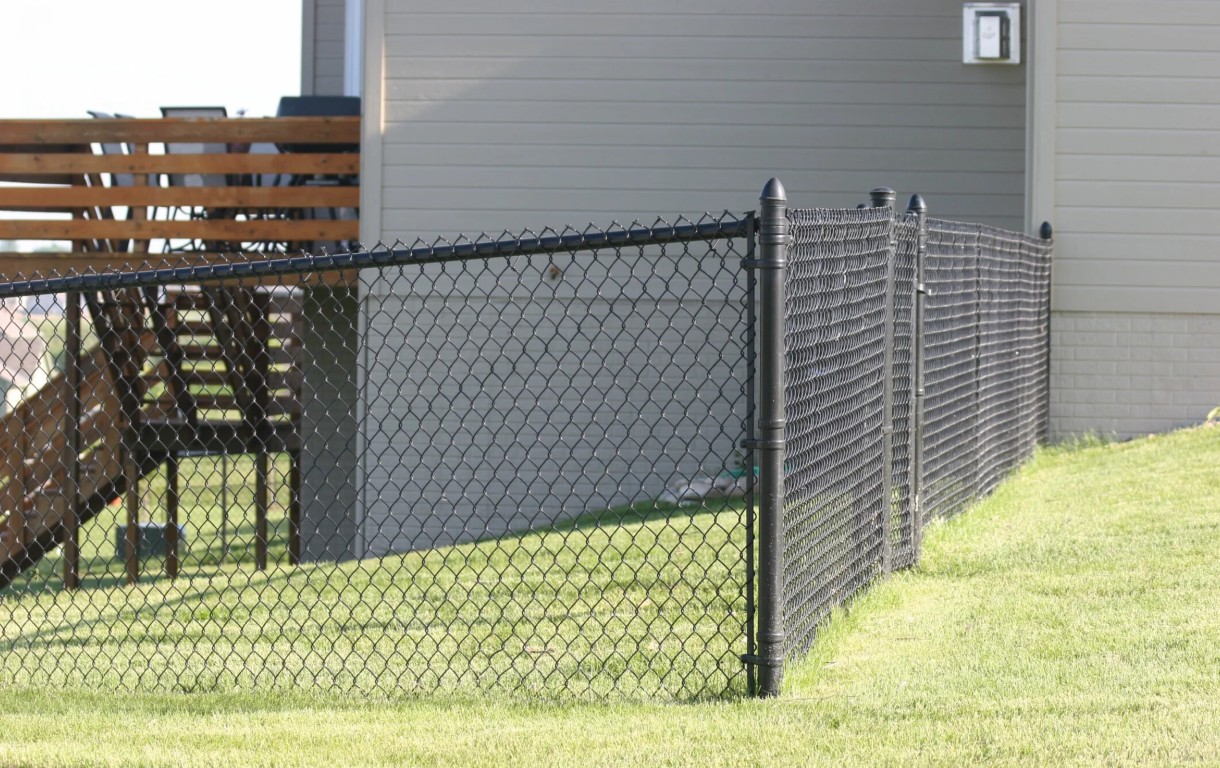 Black chain-link fence installation for backyard security and pet safety